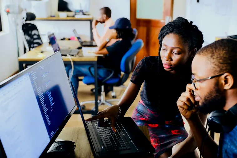 Two engineers reviewing code together on a screen